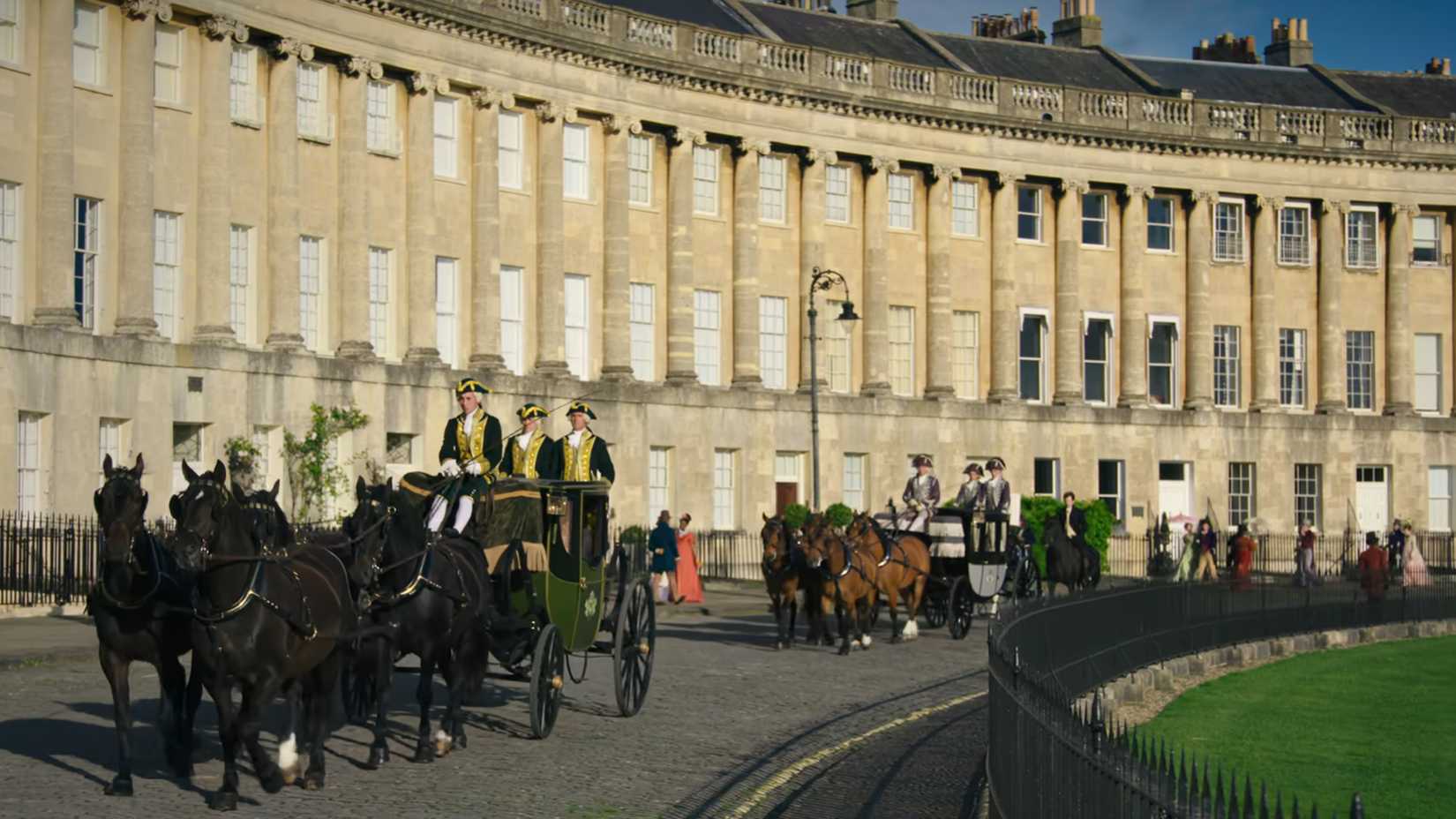 In Bridgerton season 1, episode 1, horse-drawn carriages go down a cobbled road with a yellow line