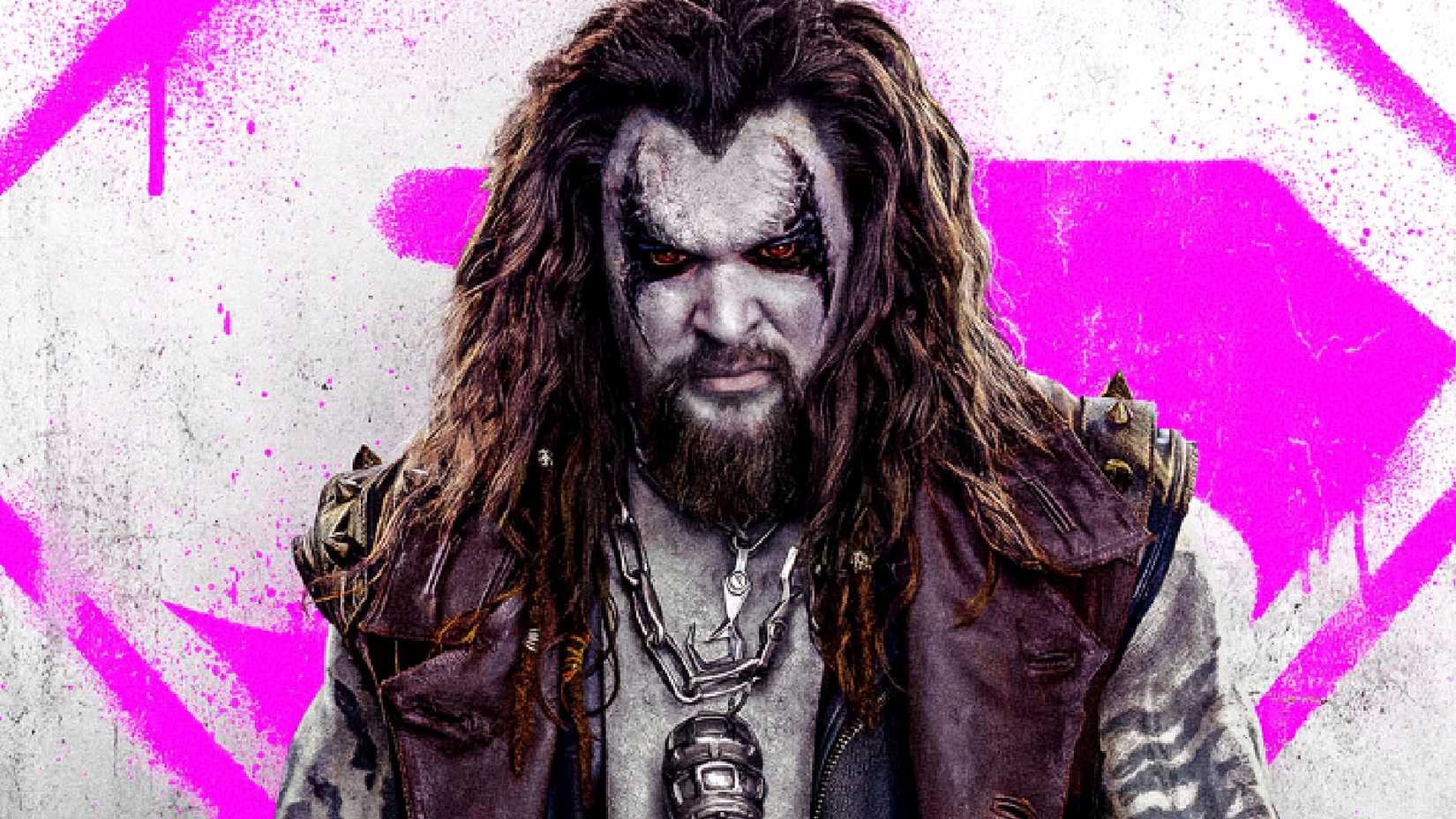 Jason Momoa's Lobo stands in front of a pink Supergirl logo