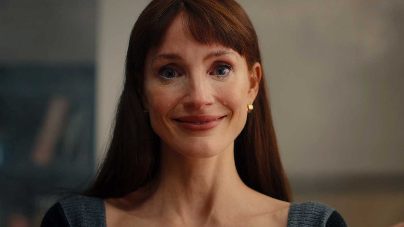 Jessica Chastain giving a tight-lipped smile as tears roll down her face in Other Mommy
