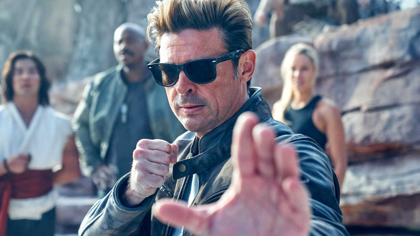 Karl Urban as Johnny Cage holding out his hand in a fighting stance in Mortal Kombat II