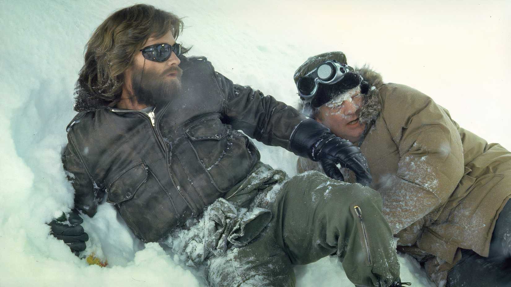 Kurt Russell and Charles Hallahan in the snow looking shocked in The Thing (1982)