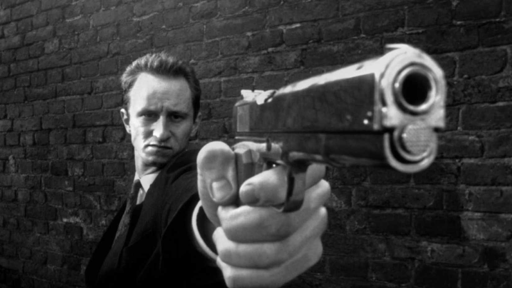 A man points a pistol in Man Bites Dog