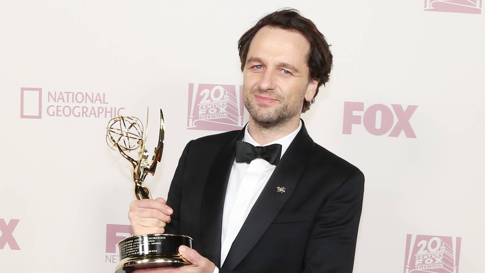 Matthew Rhys holding an Emmy