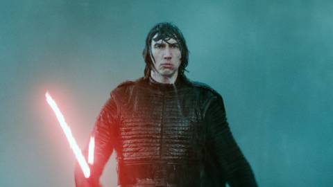 Adam Driver as Kylo Ren holding his red lightsaber in the rain in Star Wars: Episode IX - The Rise of Skywalker