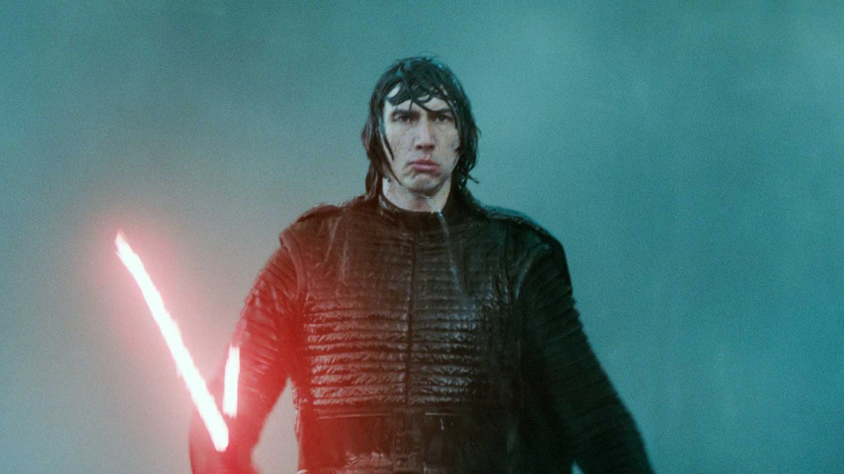 Adam Driver as Kylo Ren holding his red lightsaber in the rain in Star Wars: Episode IX - The Rise of Skywalker