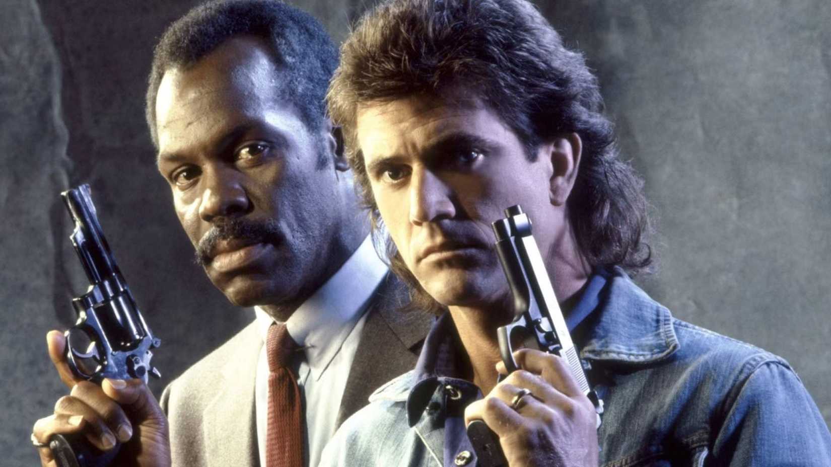 Mel Gibson and Danny Glover as Riggs and Murtaugh with guns in Lethal Weapon
