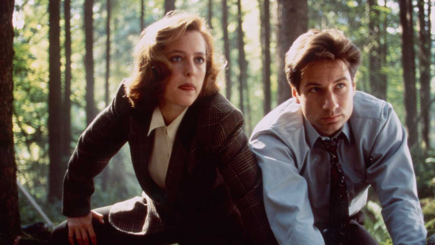 Scully and Mulder investigating in the forest in The X-Files