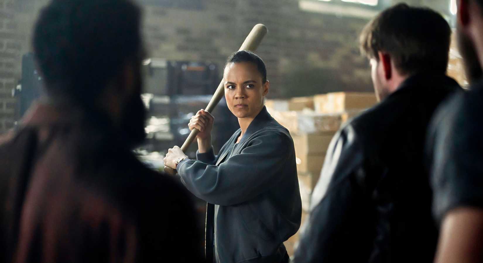 Neagley (Maria Sten) holds a bat on a group of attackers in Neagley (2026)