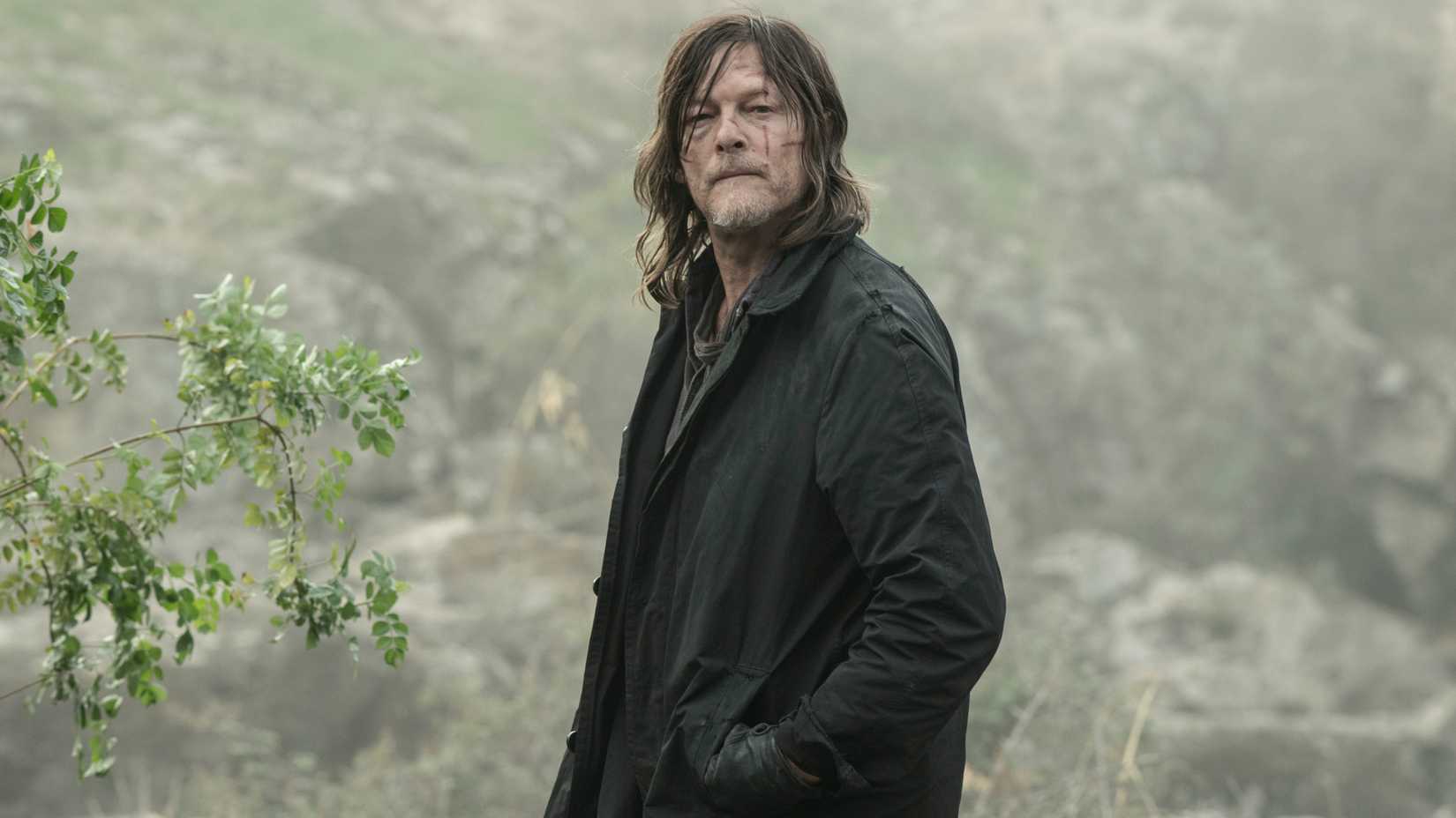Norman Reedus as Daryl Dixon with his hands in his jacket pocket looking into the distance in The Walking Dead: Daryl Dixon season 3