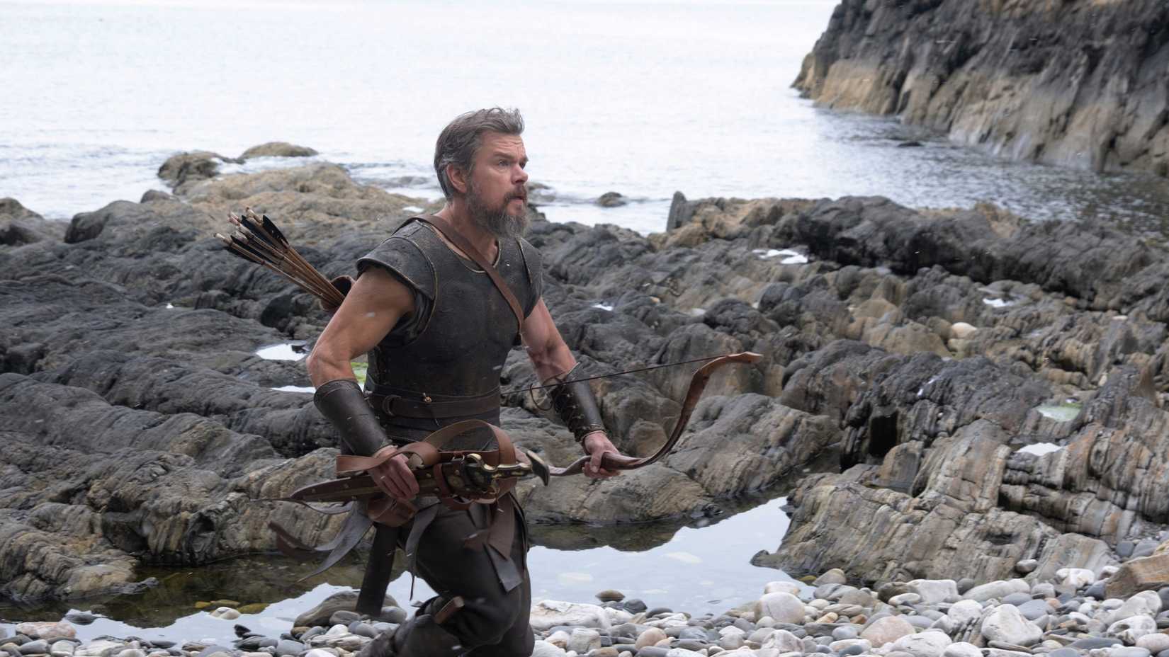 Odysseus with his bow and arrows running along a rocky shore in The Odyssey