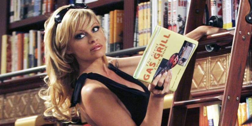 Pamela Anderson grabs a book off a shelf in Stacked
