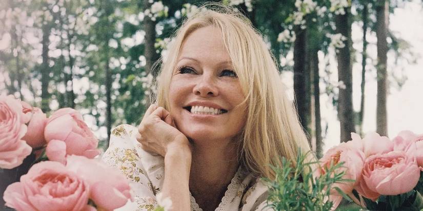 Pamela Anderson smiles with flowers around her in Pamela's Garden of Eden