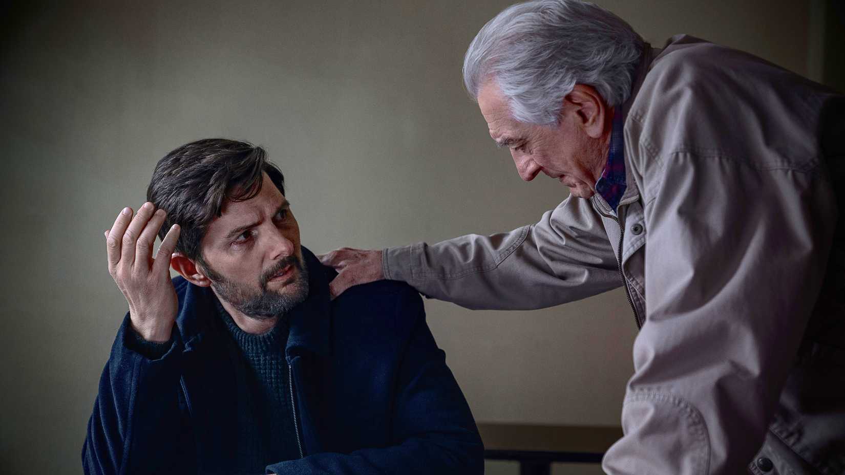 Robert De Niro's Peter with his hand on the shoulder of Adam Scott's Tom looking distraught in The Whisper Man