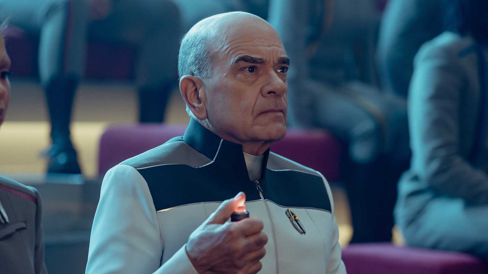 The Doctor holding a buzzer as the judge of a Starfleet Academy debate
