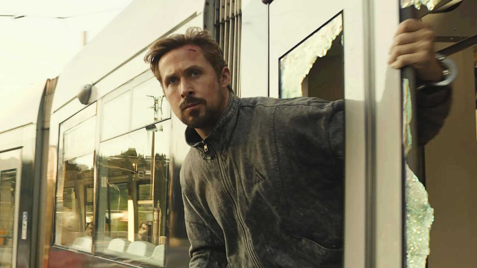 Ryan Gosling holding onto a train in The Gray Man
