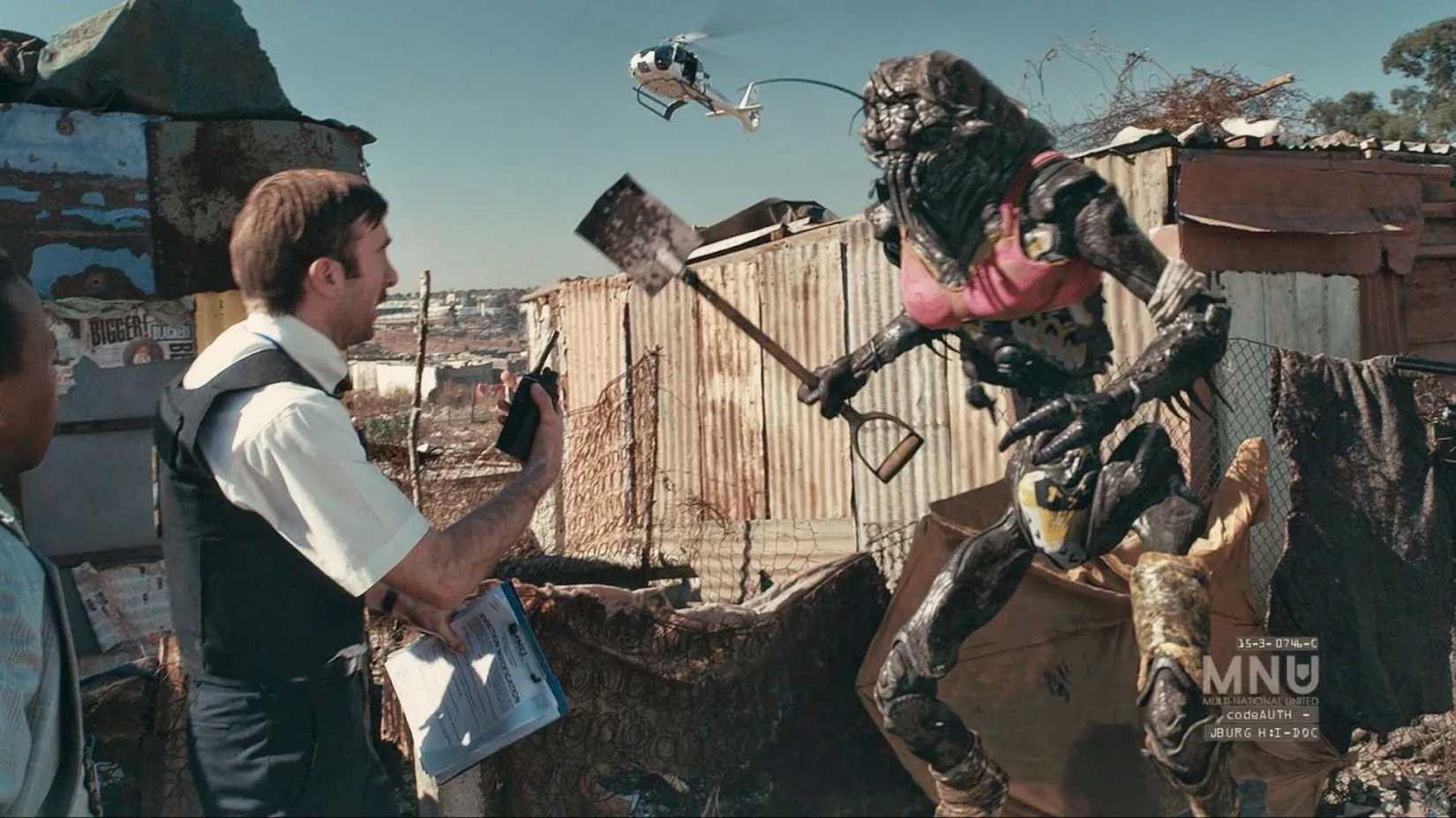 Sharlto Copley as Wikus talking to an alien in District 9