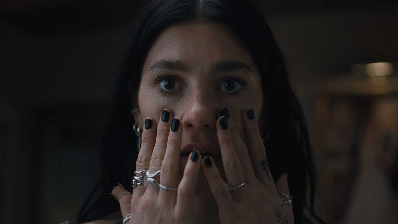 Rachel putting her hands up to her face while looking shocked in Something Very Bad is Going to Happen