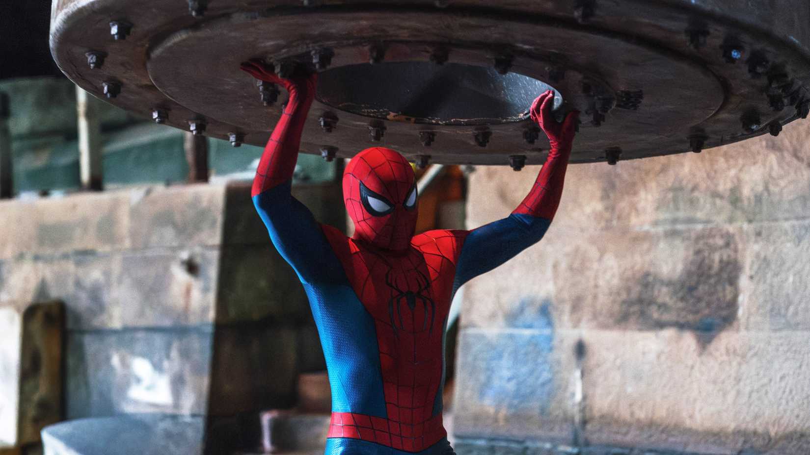 Spider-Man holding up a large piece of metal in Brand New Day
