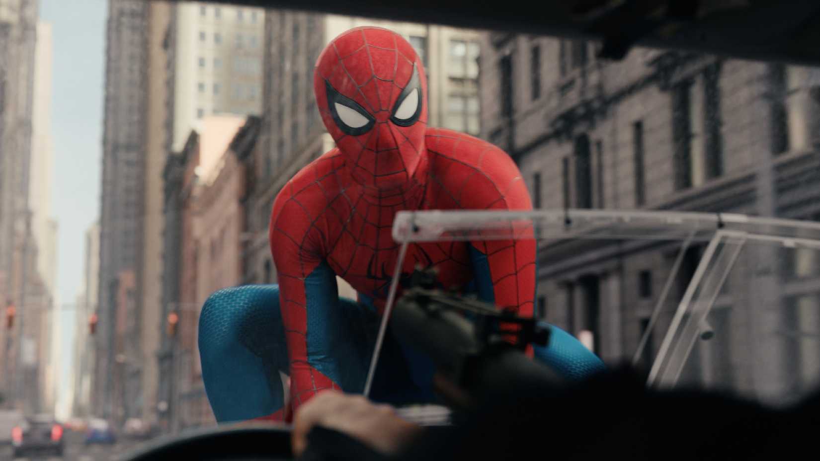 Spider-Man perched on a car hood in Spider-Man: Brand New Day.