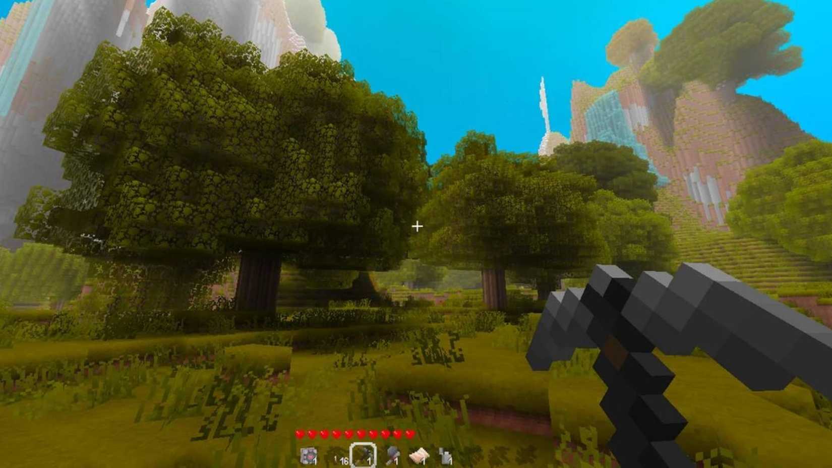 The player holding a pickaxe while looking at a forest in Terasology.