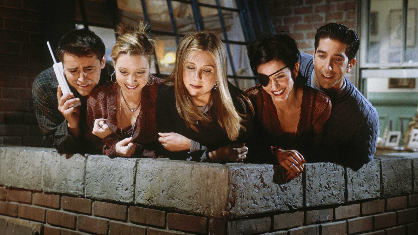 The Friends gang without Chandler peering over the apartment balcony.