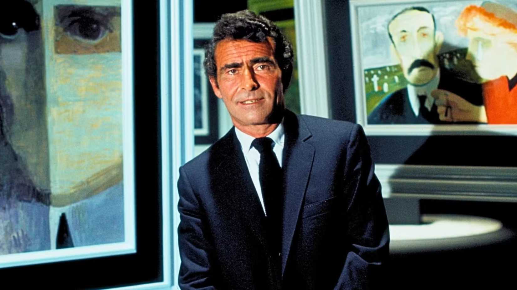 Rod Serling posing in front of paintings in The Night Gallery