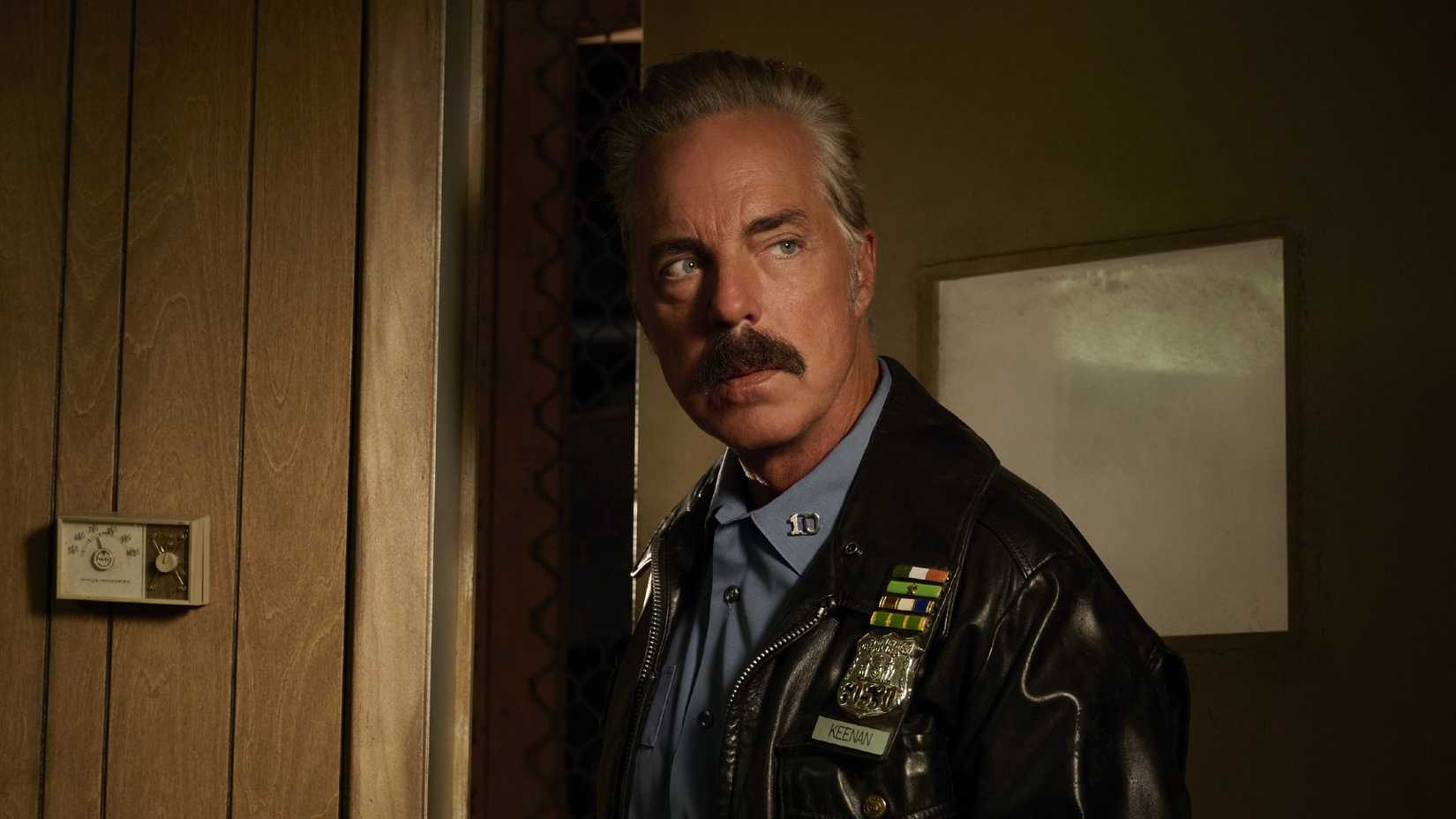 Titus Welliver as Officer Glenn Keenan leans against a doorway in The Westies