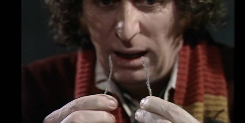 Tom Baker as the Fourth Doctor holding two wires in Doctor Who.