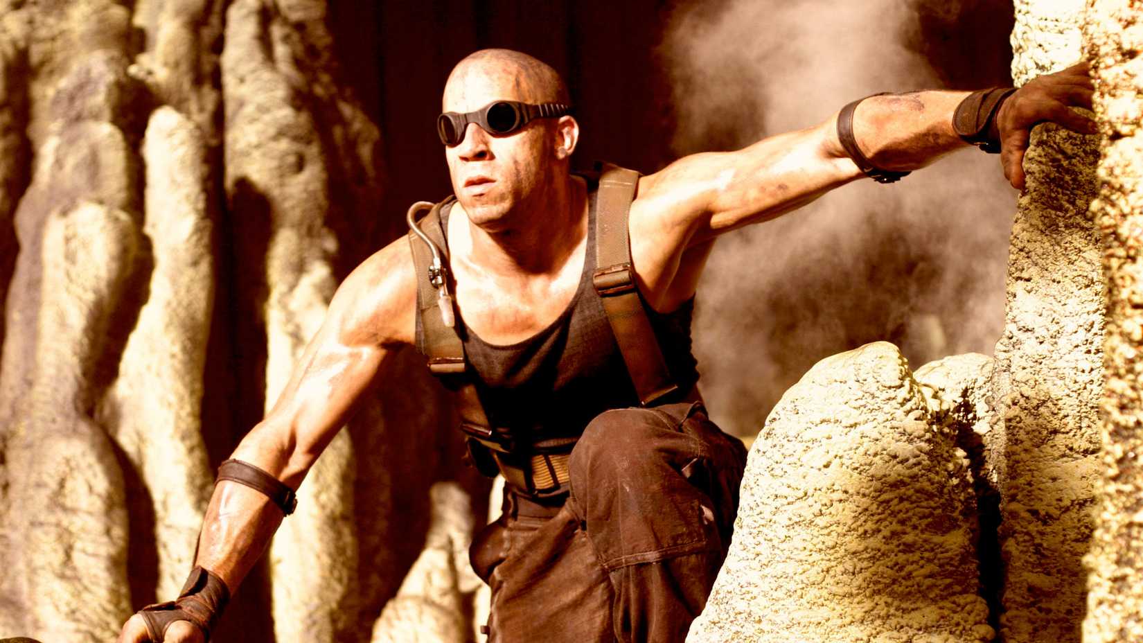 Vin Diesel climbing out of a cave bathed in light in The Chronicles Of Riddick