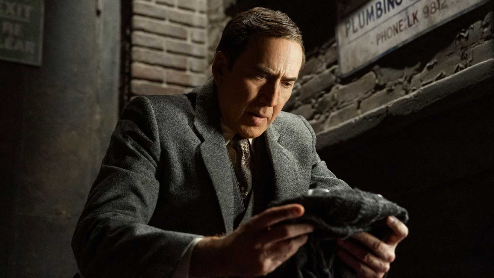 Nicolas Cage examining something in Spider-Noir