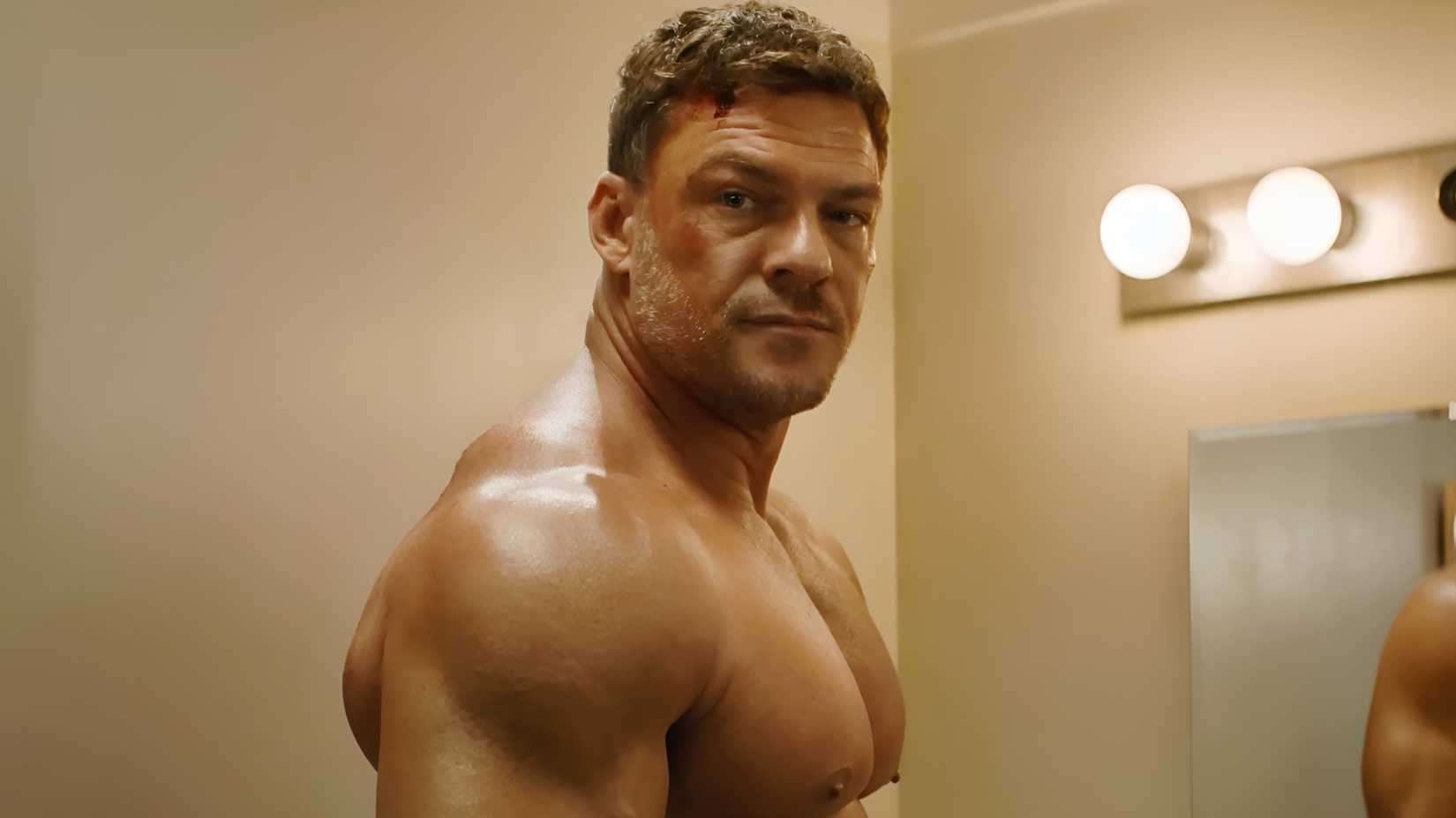 Alan Ritchson’s Jack Reacher standing shirtless and looking at Lila in Reacher season 4