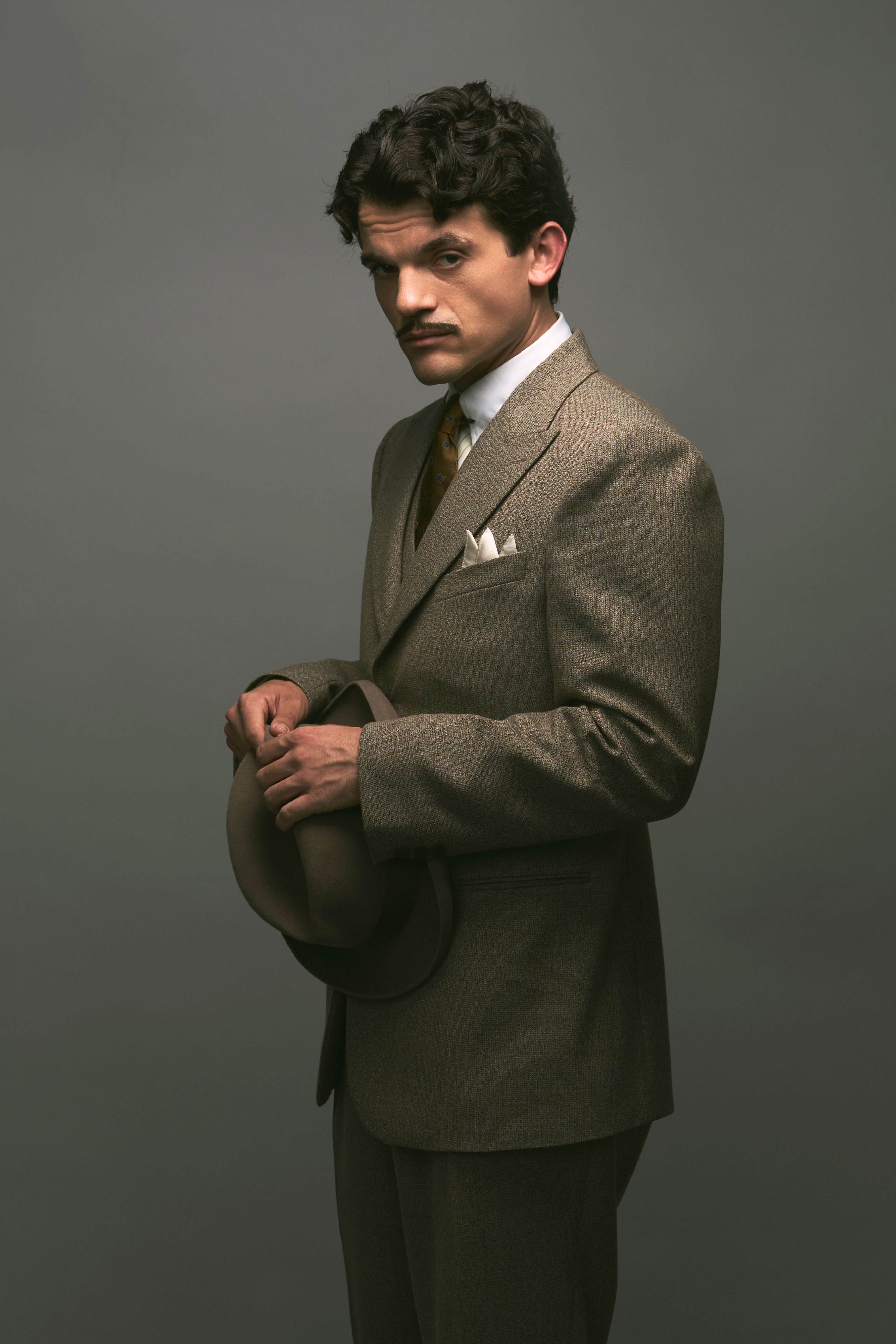 A full body image of Edward Blumel as Hercule Poirot