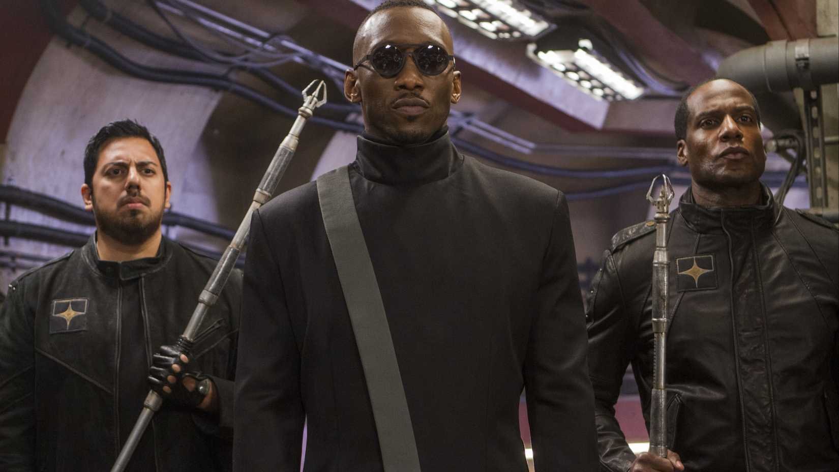 Mahershala Ali as Vector flanked by two soldiers in Alita: Battle Angel.