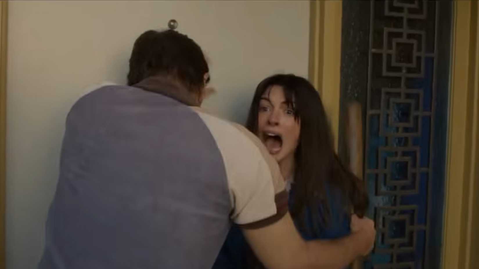 Anne Hathaway screaming with Ewan McGregor as dinosaurs approach in the end of oak street