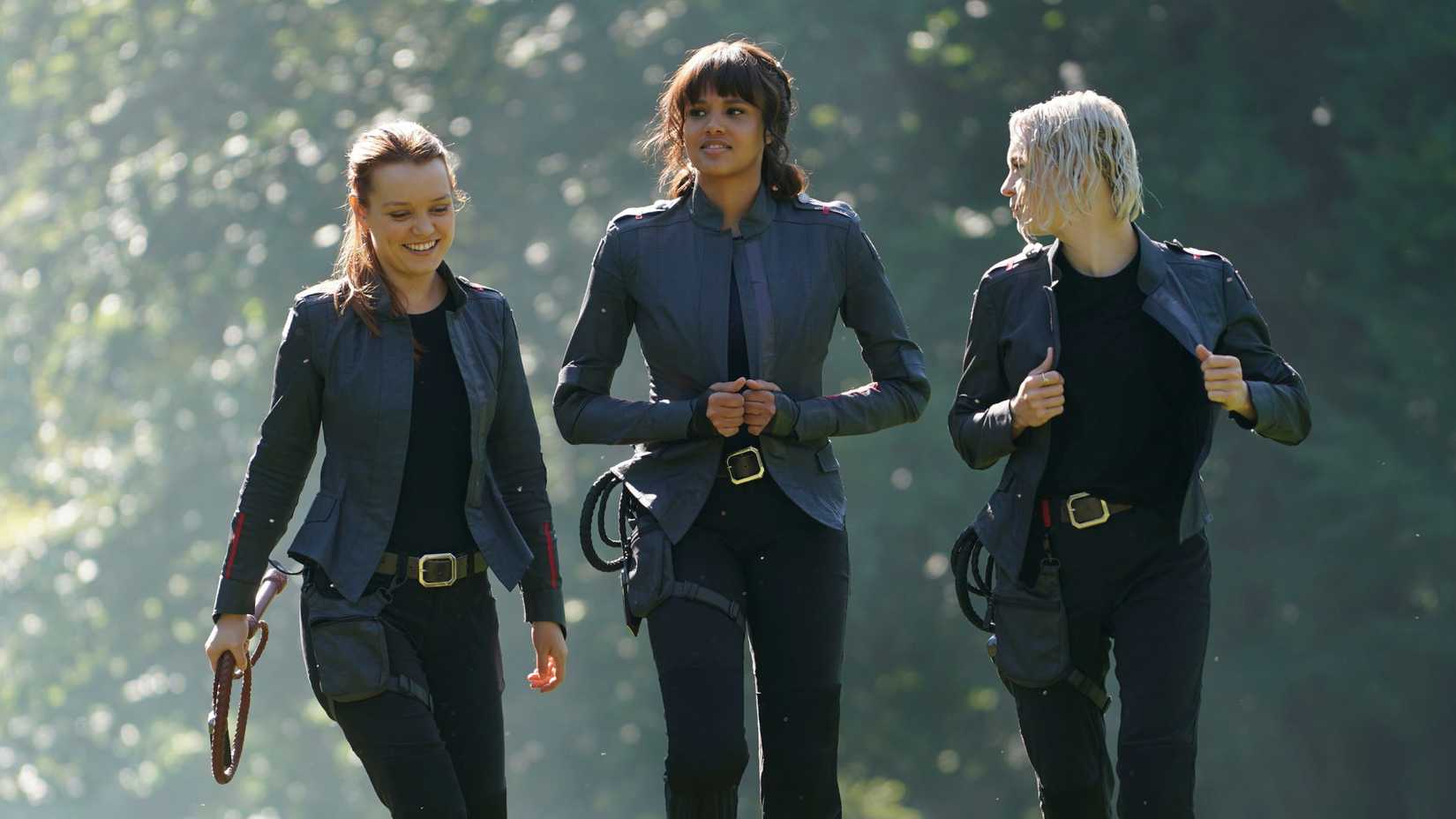 Tally, Abigail, and Raelle walking in uniform in the sun at Fort Salem in Motherland Fort Salem.