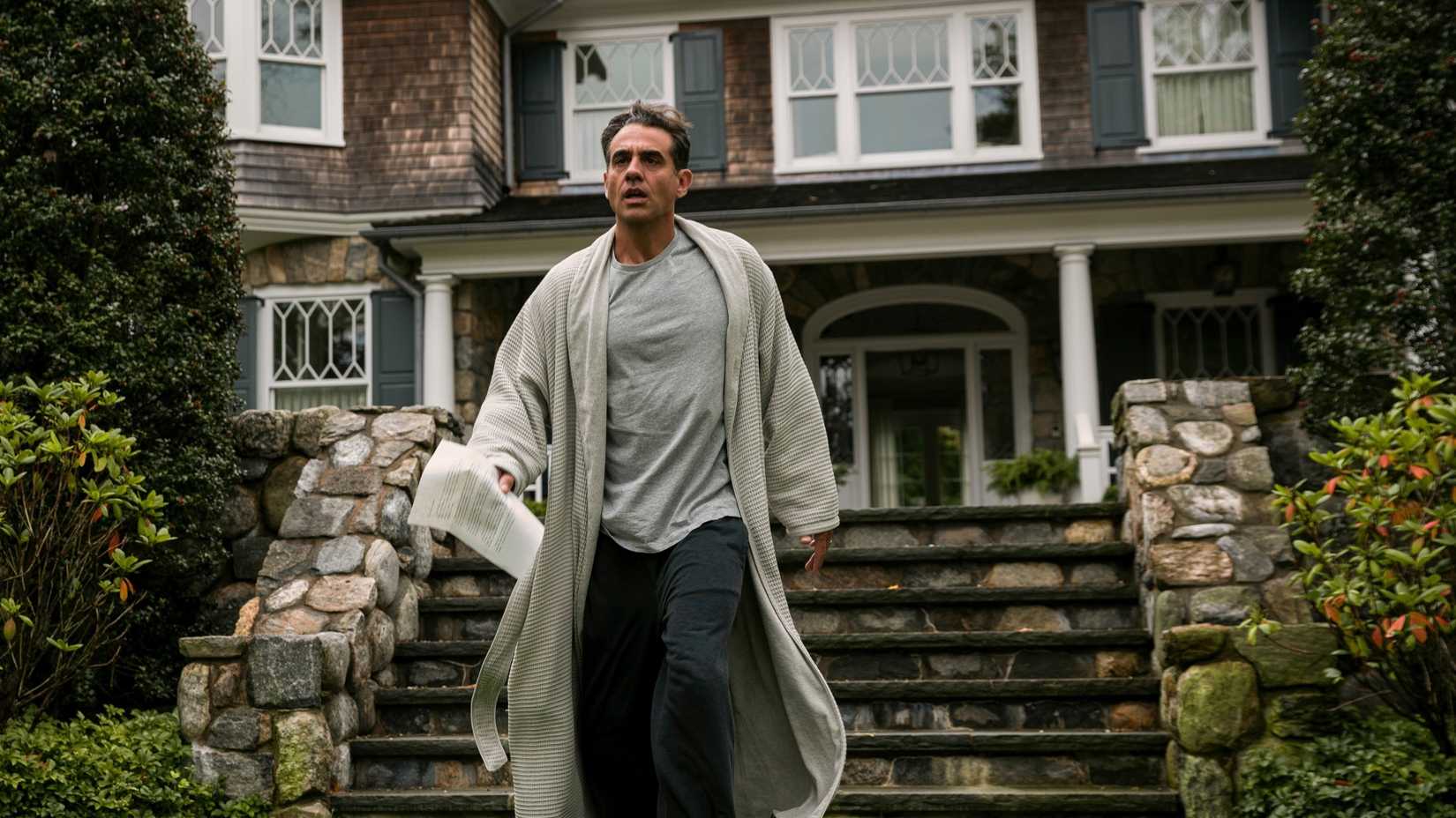 Bobby Cannavale as Dean walking in his bathrobe with 657 Boulevard behind him in The Watcher