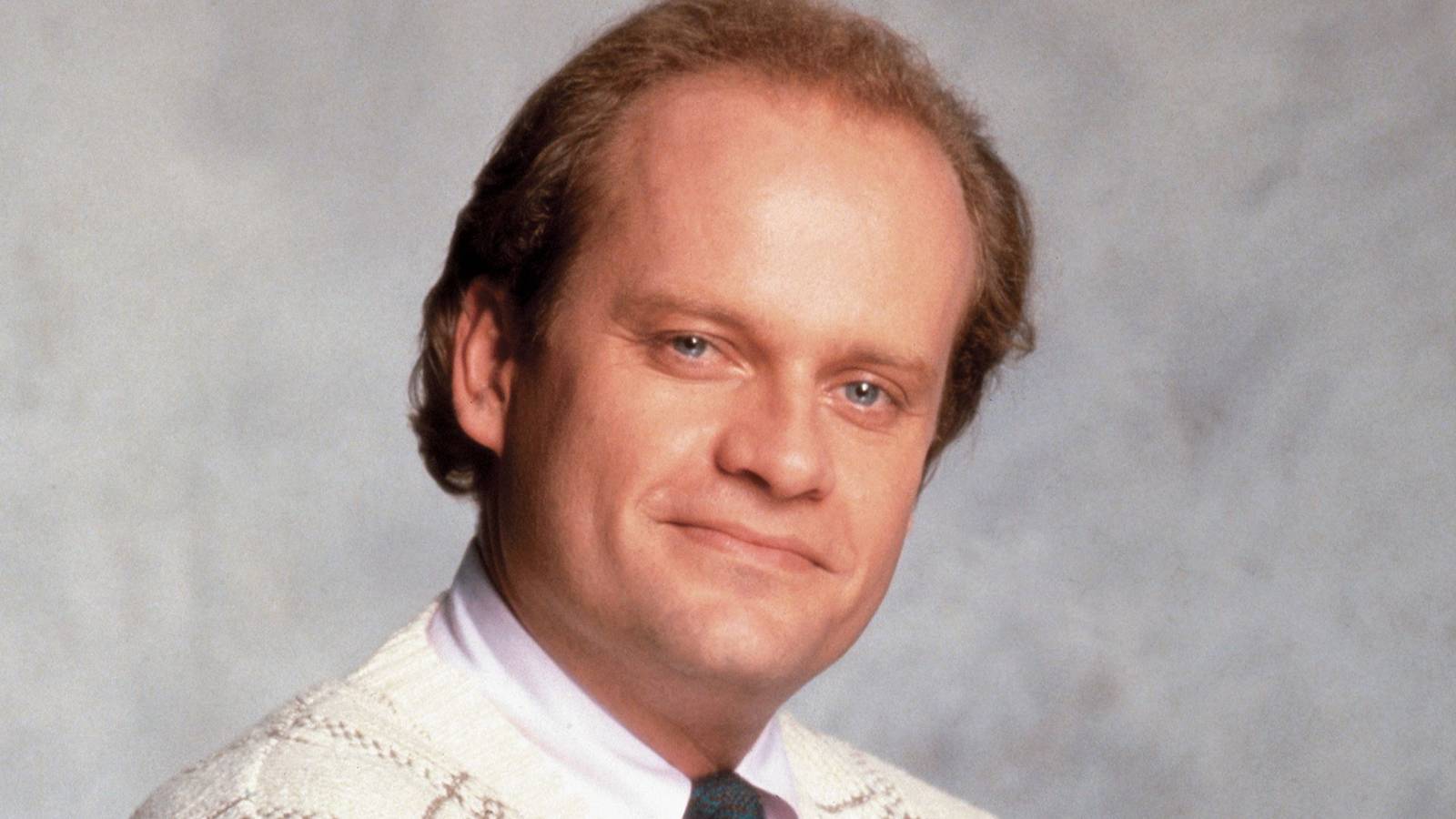Frasier (Kelsey Grammer) smiling for the camera in Cheers.
