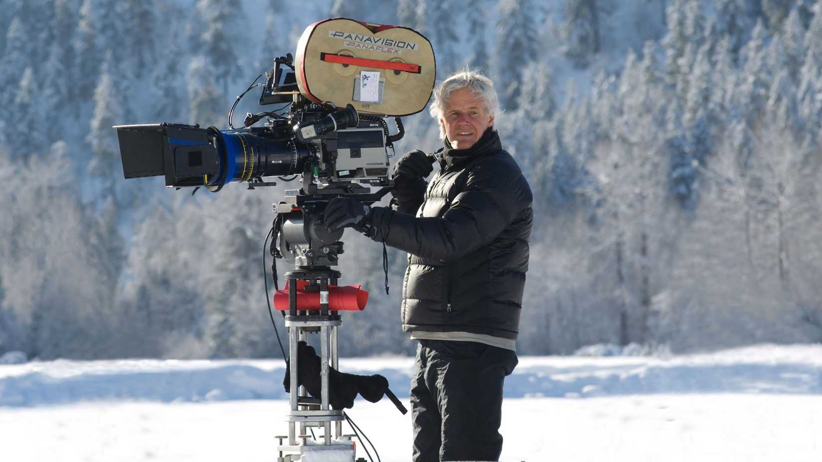 Chris Carter standing behind a camera in a snowy field in The X-Files: I Want to Believe set