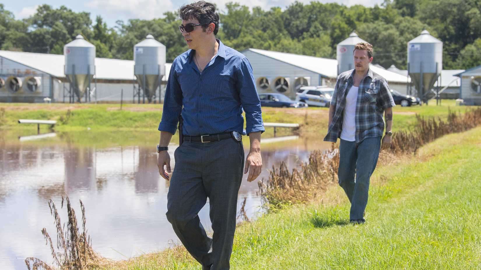 Chris Messina and Will Chase walking across a resevoir in Sharp Objects