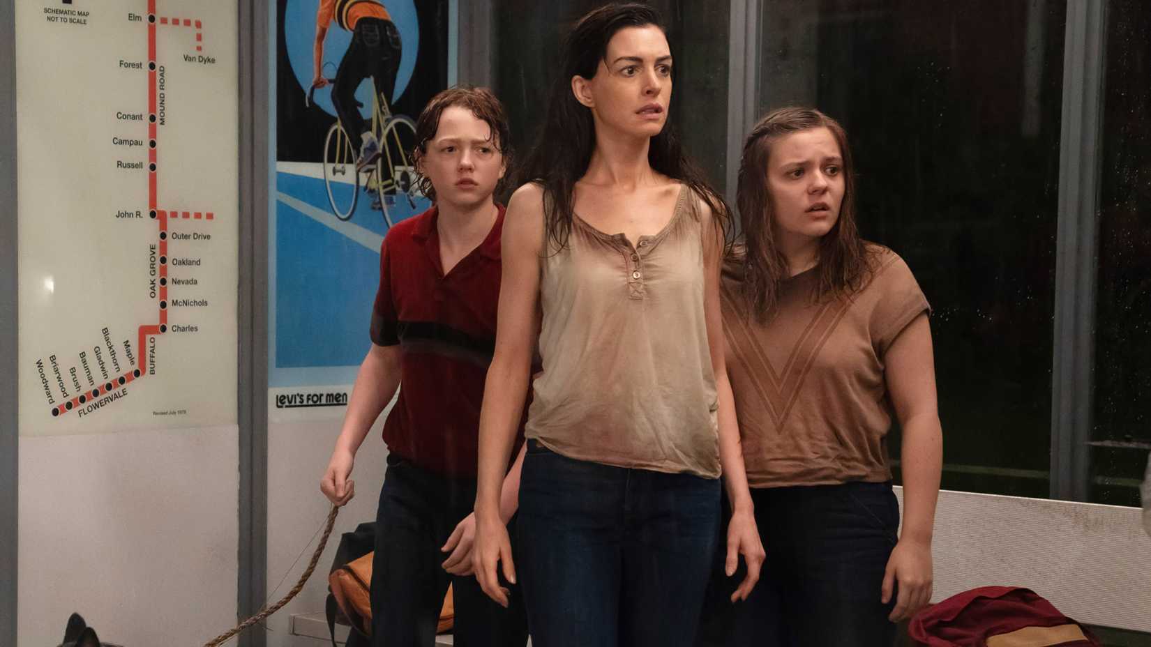 Christian Convery's Brian, Anne Hathaway's Denise and Maisy Stella's Audrey looking worried at a bus stop in The End of Oak Street