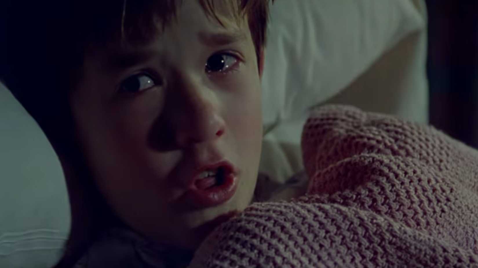 Cole pulling a blanket up to his face scared in The Sixth Sense