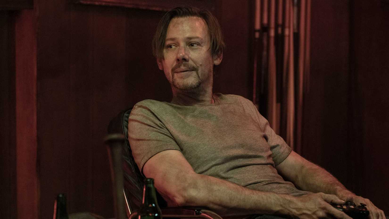 Dillard (Jimmi Simpson) sitting with a controller in his hand in The Walking Dead: Dead City