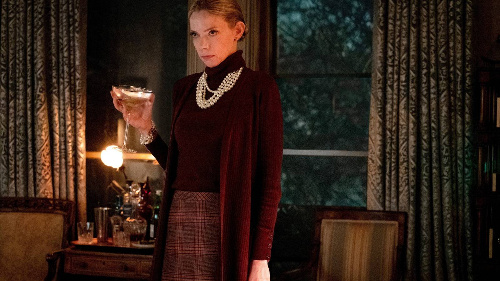 Donna Thrombey (Riki Lindhome) holding a glass of champagne menacingly in Knives Out