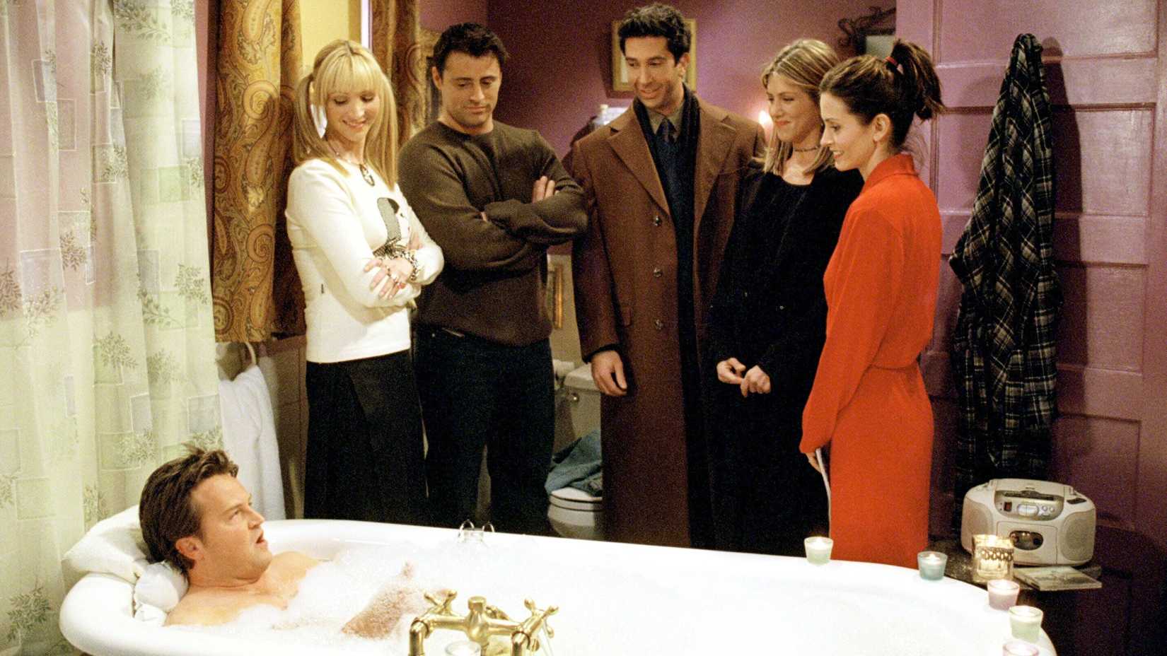 Chandler in a bath surrounded by Phoebe Joey Ross Rachel and Monica