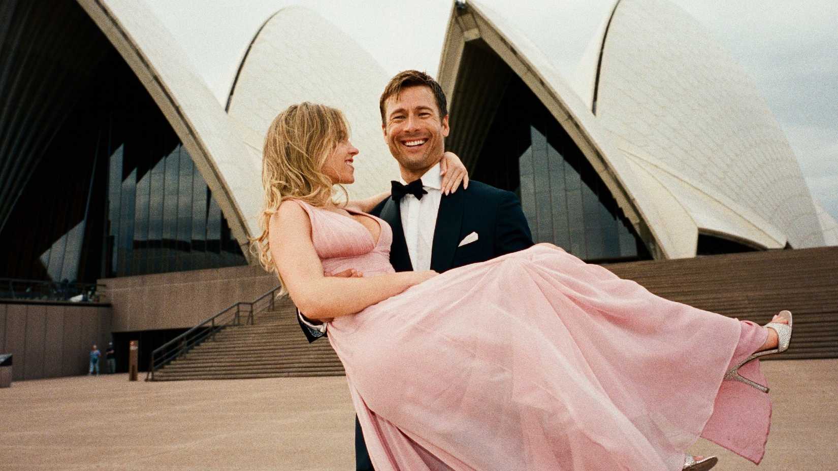 Glen Powell carrying Sydney Sweeney in Anyone But You