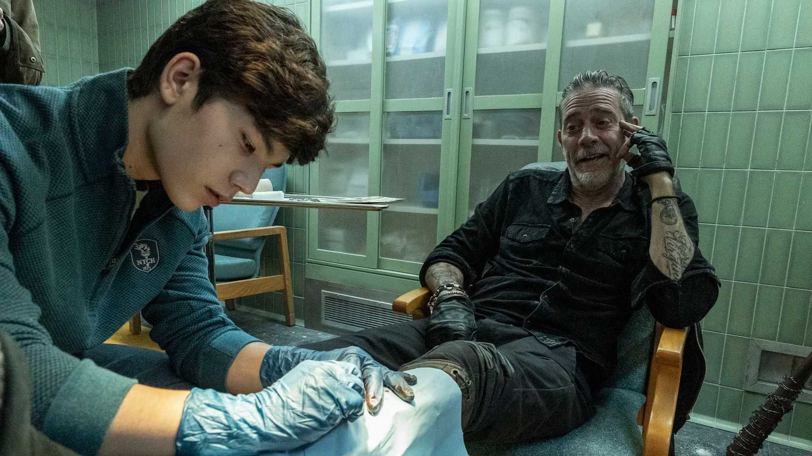 Hershel (Logan Kim) treating Negan's (Jeffrey Dean Morgan) wound in The Walking Dead: Dead City season 2