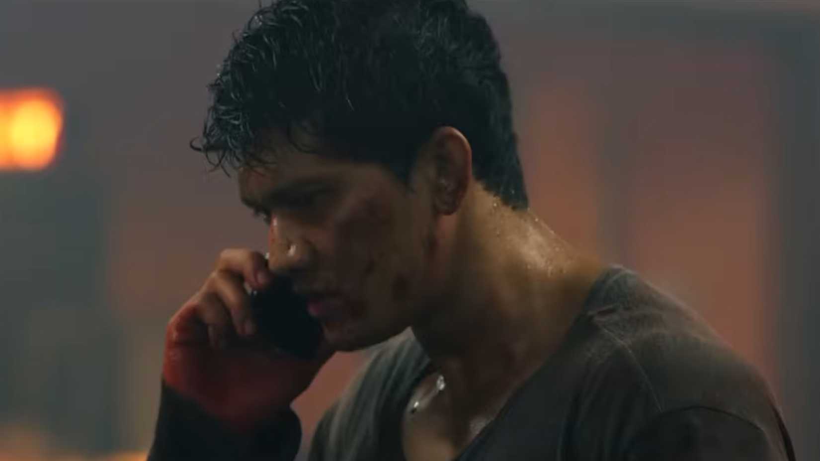 Iko Uwais on the phone with blood on his hands in headshot