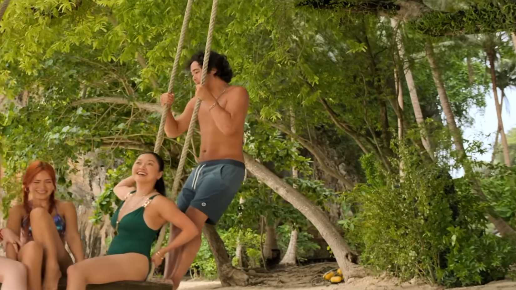 James (Nico Hiraga) on a swing with the group on a beach in The Devil's Mouth