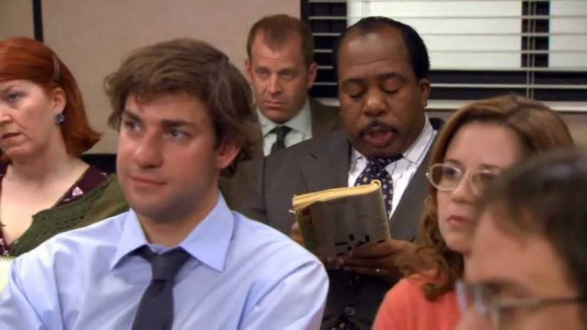 Jim (JohnK Krasinski) sitting in front of Stanley (Leslie David Baker) in the meeting room in The Office, Did I Stutter.
