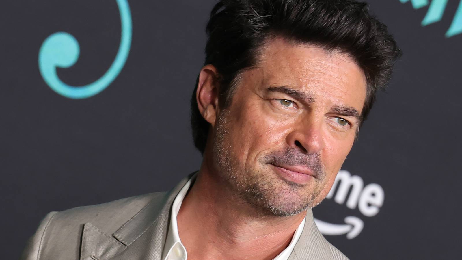 Karl Urban smiling while on The Bluff red carpet